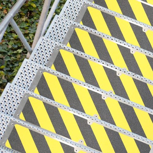antypoślizgowe nakładki aluminiowe zamontowane na schodach zewnętrznych w ostrzegawczym kolorze czarno żółtym