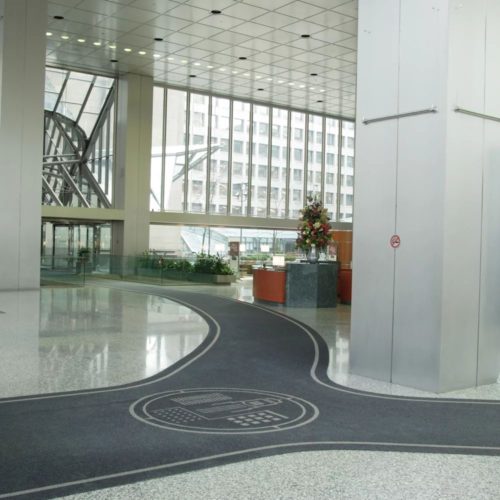 mata z logo Precision Loop ułożona w przestrzeni wejściowej w wpustach posadzkowych w dużym holu firmowym
